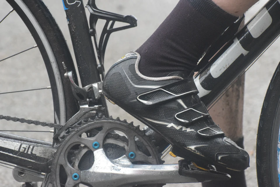 A cyclist's shoe clipped into the pedal of a road bike